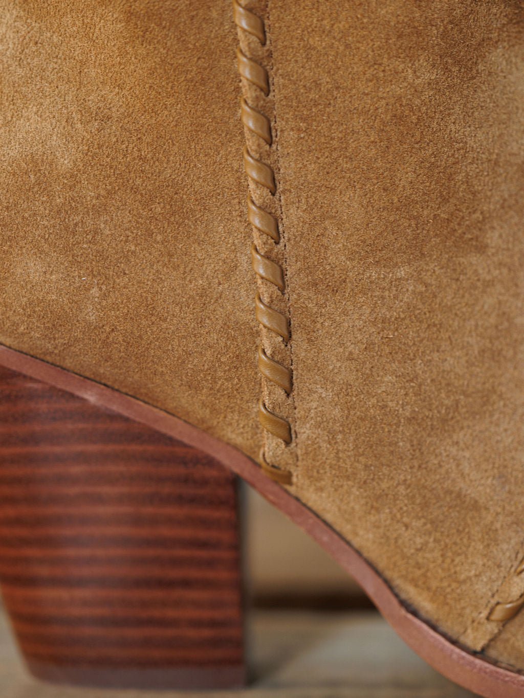 Close-up of The Cerritos by Savannah Sevens western life{&}style, a suede bootie with decorative side stitching and a stacked heel, showcasing the material's texture and detailed craftsmanship.