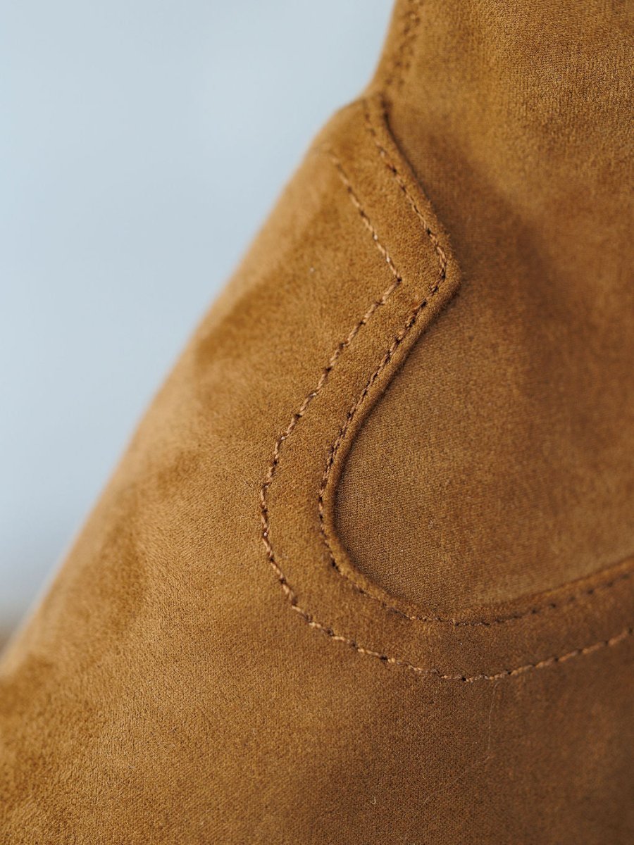 Close-up of The Palmetto bootie by Savannah Sevens western life{&}style, showcasing light brown faux suede material with visible stitching and seam; texture is soft and smooth.