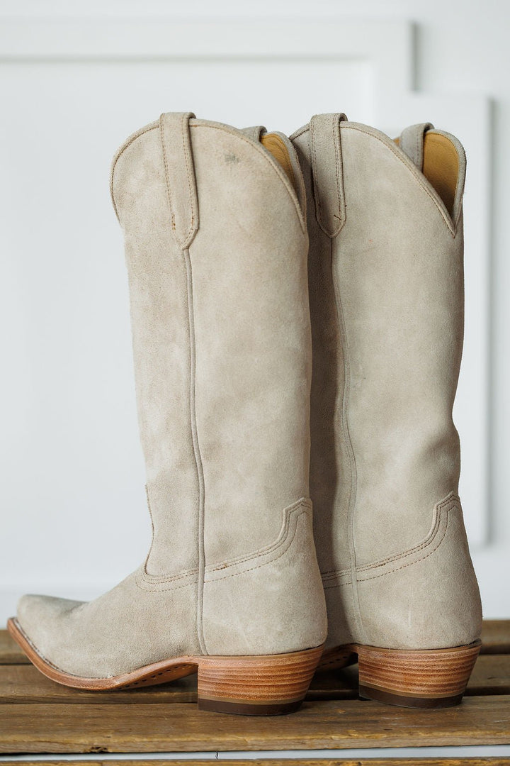 The Shiloh by Savannah Sevens western life{&}style: light beige suede western boots with stacked wooden heels and a classic snip toe, displayed side by side on a wooden surface against a white background. Made by Black Star. 