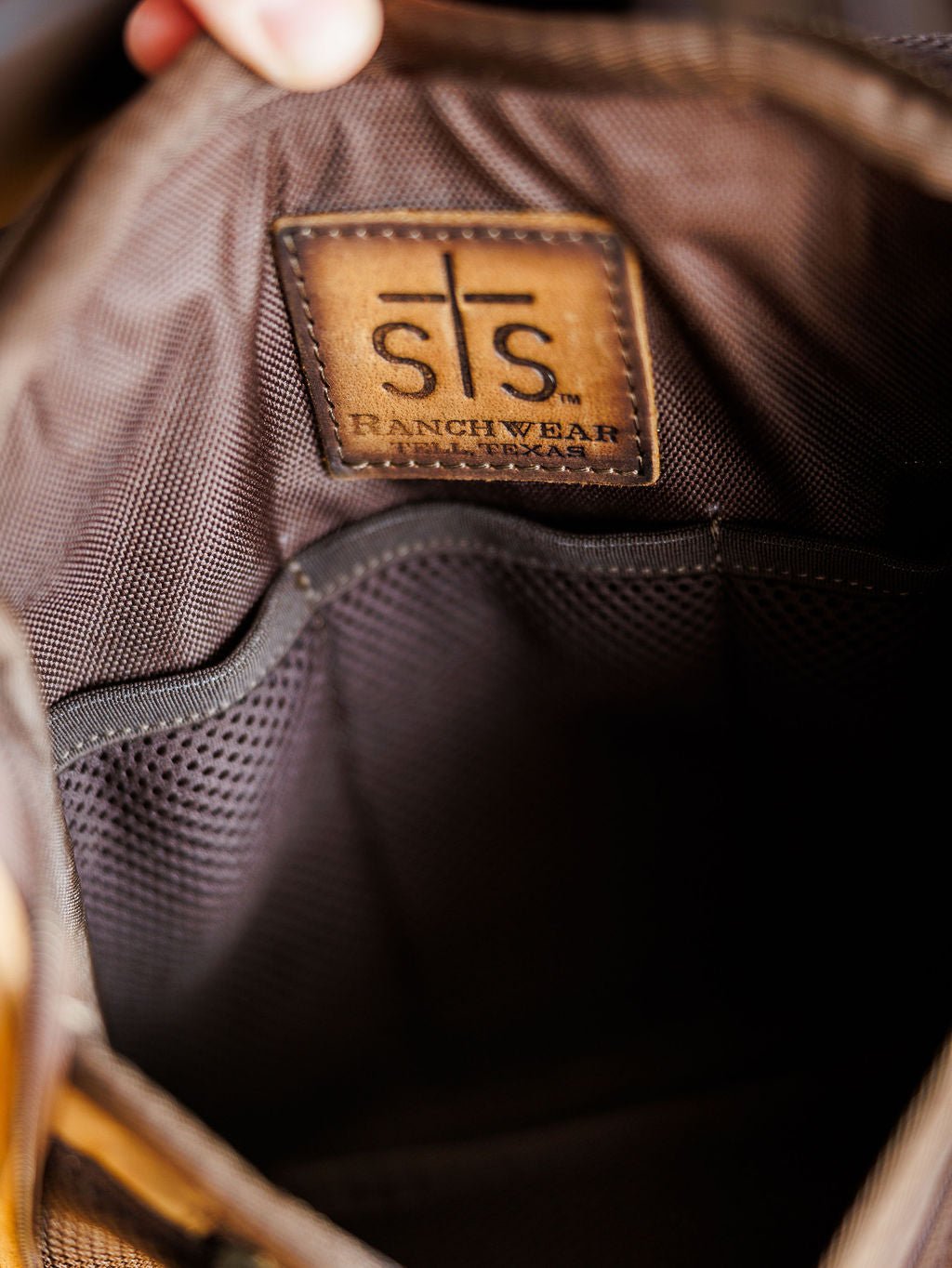 Close-up of The Toledo shave kit by Savannah Sevens western life{&}style, featuring a brown fabric interior, stitched leather patch, and mesh pocket—perfect for organizing essentials in this hanging toiletry bag.