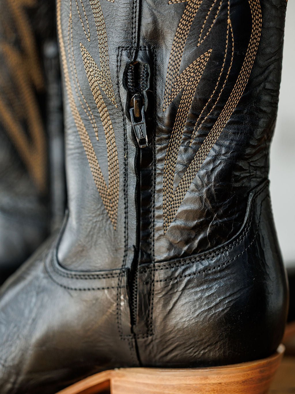 Close-up of The Vaquera by Savannah Sevens western life{&}style: a black leather snip toe boot with tan stitching, western embroidery, a visible side zipper, and a wooden stacked heel. Made by Black Star. 