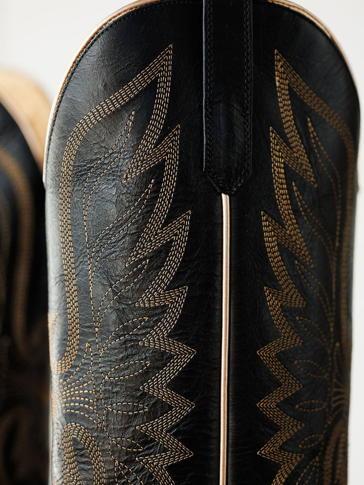 Close-up of The Vaquera by Savannah Sevens western life{&}style: a black leather snip toe boot with intricate golden stitching in a decorative pattern, highlighting the classic style of western embroidery boots. Made by Black Star. 