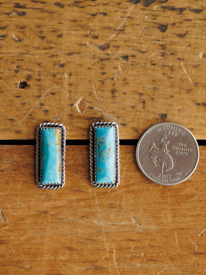 The Toano Earrings by Savannah Sevens western life{&}style feature rectangular turquoise bars with silver rope borders, shown beside a 2007 Wyoming state quarter for size. These Navajo handcrafted sterling silver earrings are striking and unique.
