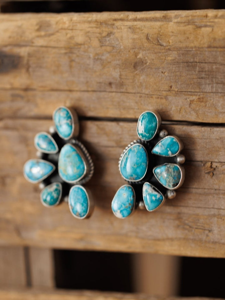 The Watseka Earrings by Savannah Sevens western life{&}style are Native American handcrafted turquoise clusters set in sterling silver, beautifully displayed on rustic wood.