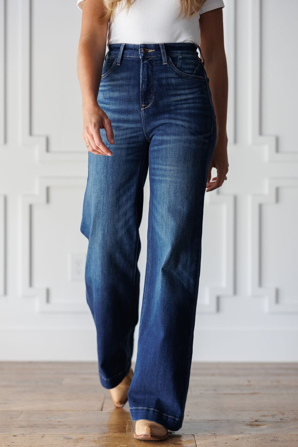 A person wearing ultra high-rise, wide-leg Yates High Rise Wide Leg Jean by Ariat in a medium dark wash.