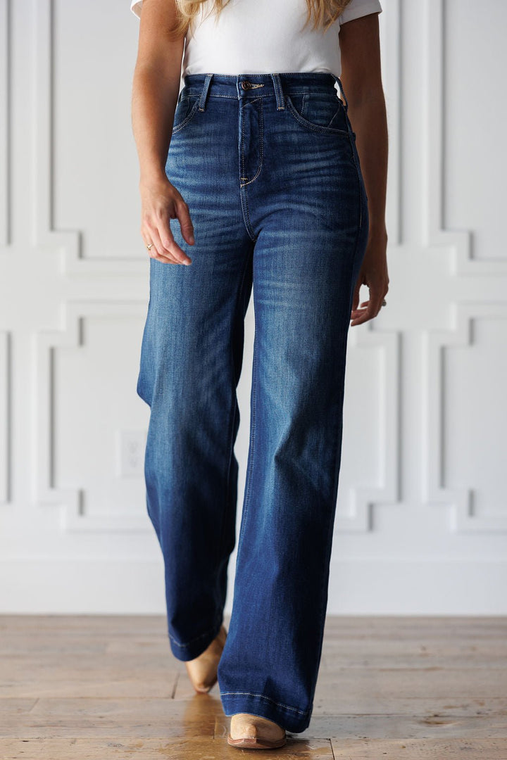 A person wearing ultra high-rise, wide-leg Yates High Rise Wide Leg Jean by Ariat in a medium dark wash.