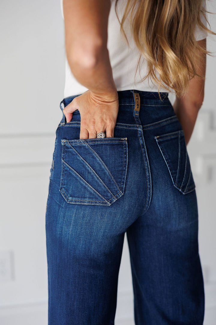 Back view of medium dark wash Yates High Rise Wide Leg Jean by Ariat, featuring a wide-leg silhouette and angled stitching detail on the back pockets.