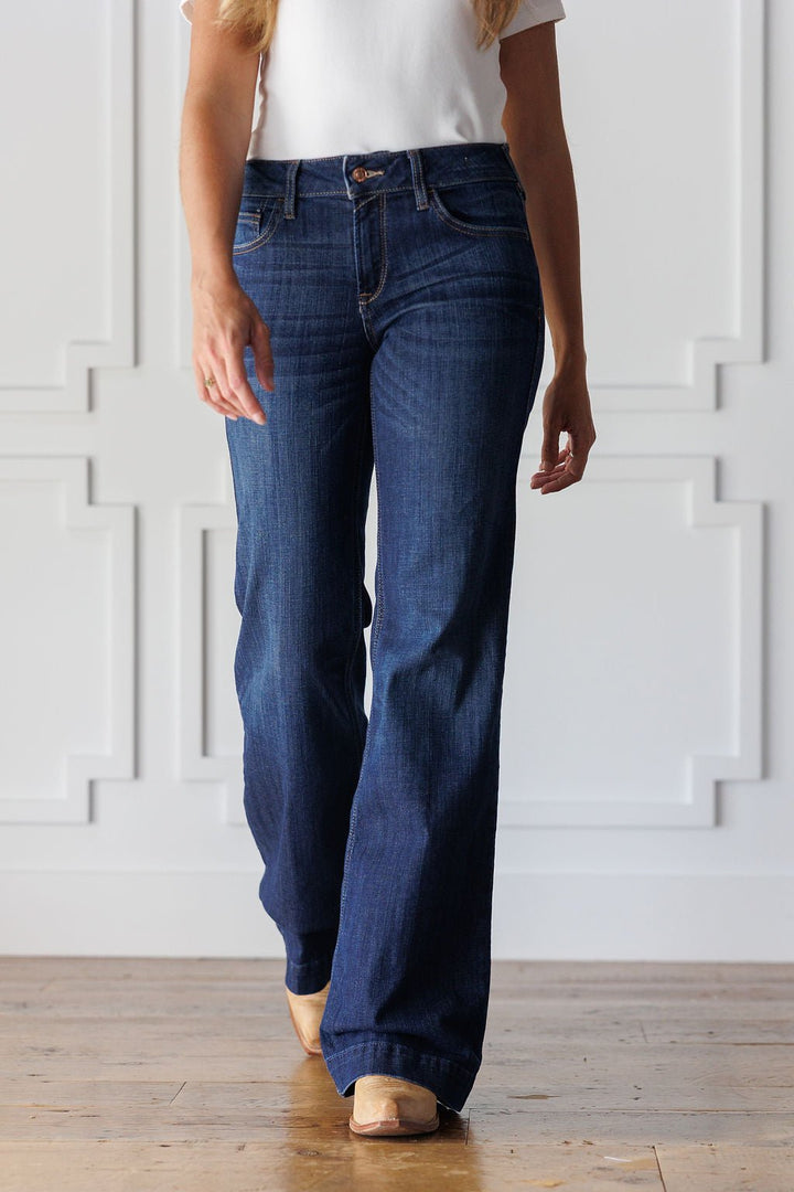 A person wearing medium dark wash Yoakum Perfect Rise Trouser Jean by Savannah Sevens western life&style and tan pointed-toe boots.