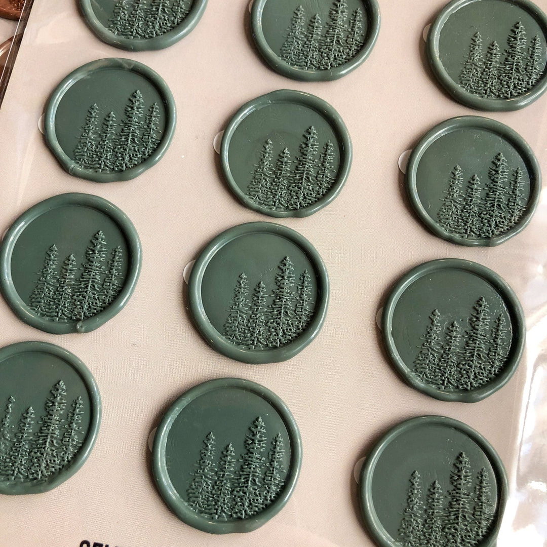 Savannah Sevens western life{&}style Pines Wax Seal features round, self-adhesive seals embossed with pine trees, neatly arranged on a light surface. Each wax stamp displays a cluster of evergreens in relief.